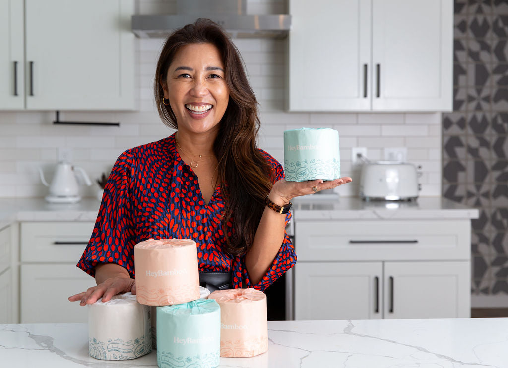 Asian American mom Joslyn holds up a roll of her environmentally friendly bamboo toilet paper.
