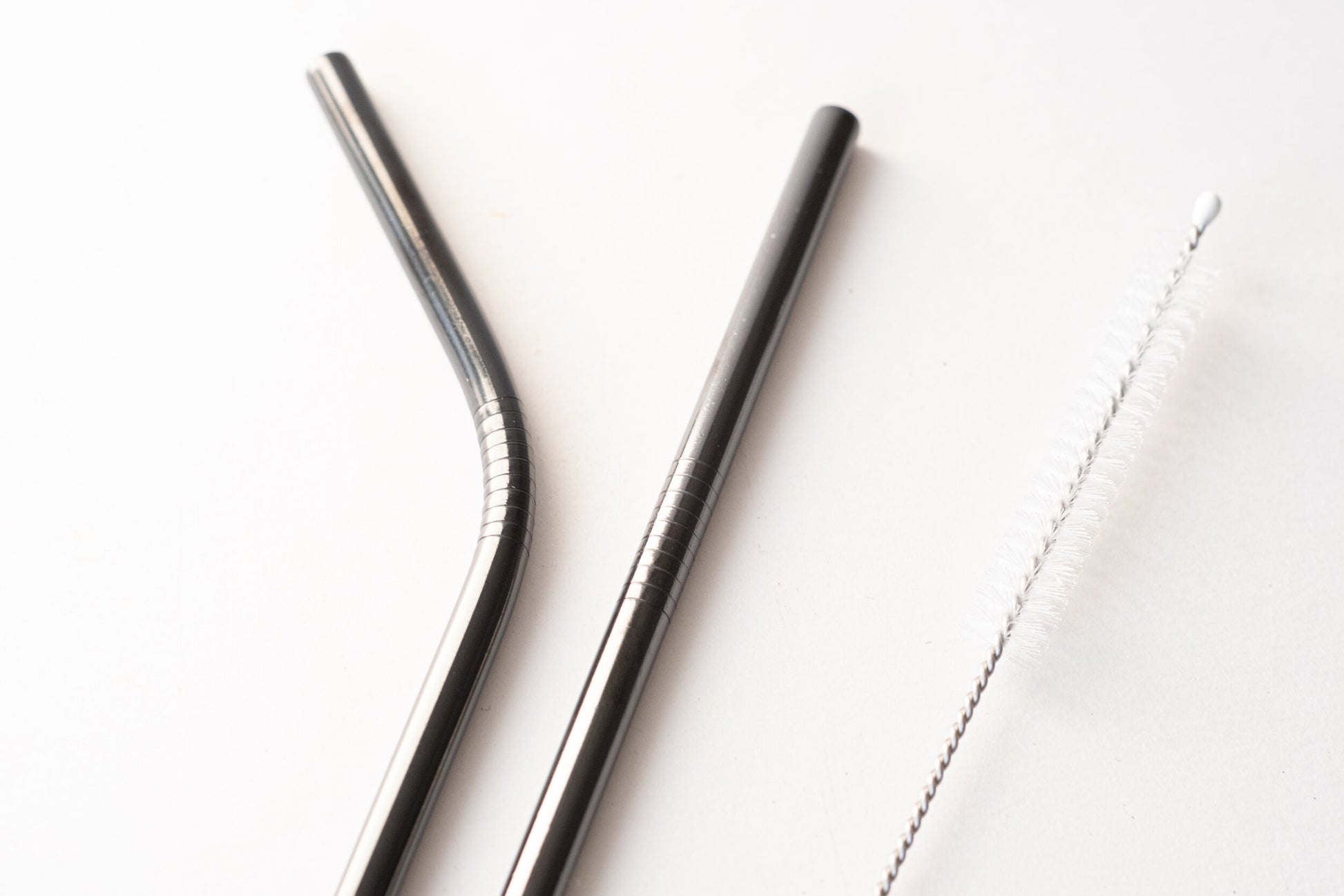Two silver straws with a utilitarian cleaner.
