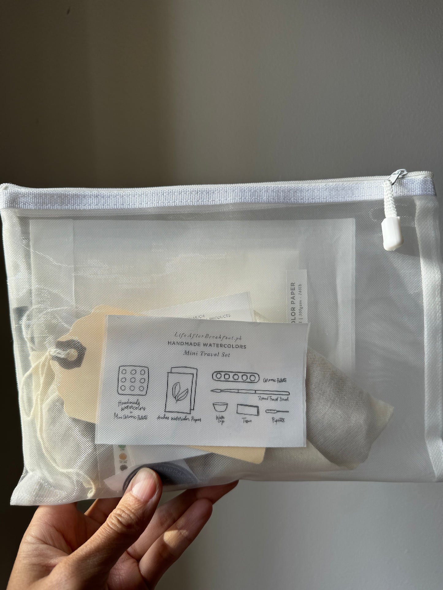 A convenient pouch with the useful and inspiring travel watercolor kit items.