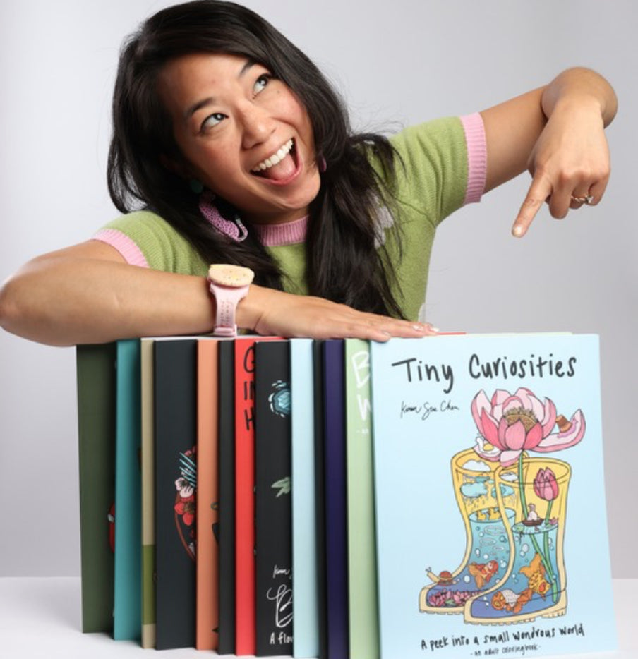 Sacramento-based Taiwanese-American artist Karen Chen points at a lineup of her inspiring coloring books.