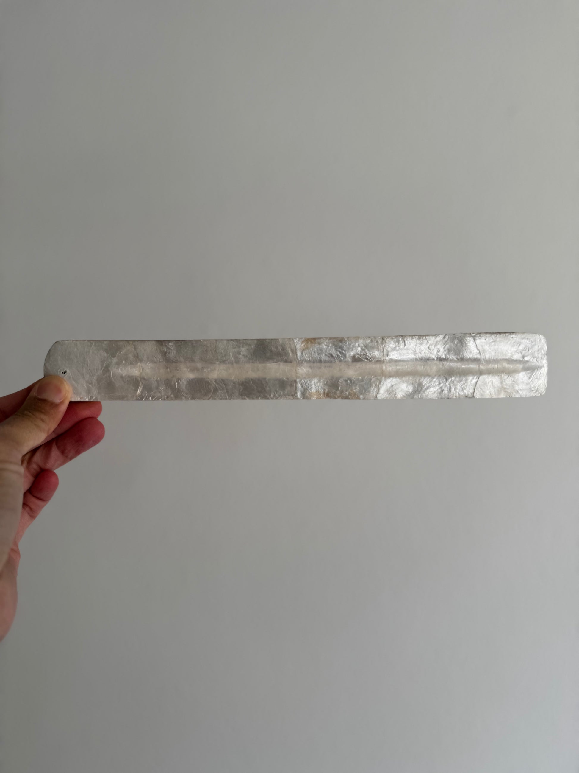 The capiz shell incense holder is rectangular with a large indent for the incense.
