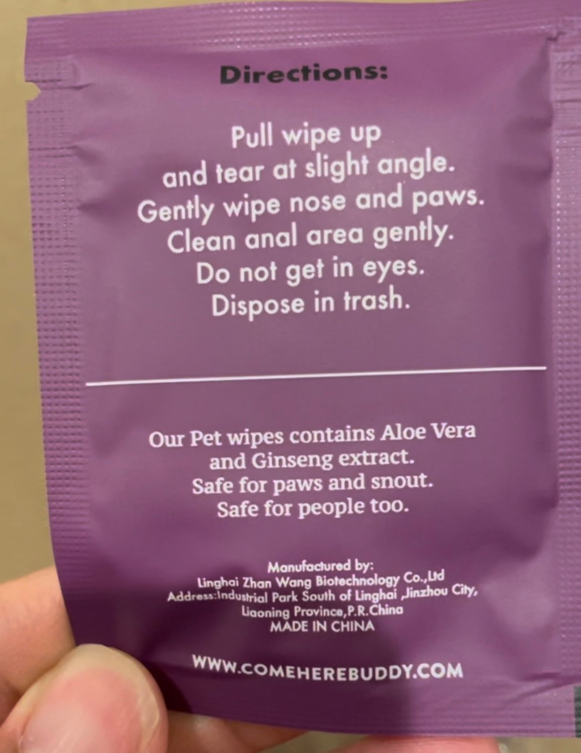 Directions on the back of the packet: "Pull wipe up and tear at slight angle. Gently wipe nose and paws. Clean anal area gently. Do not get in eyes. Dispose in trash." Other text: "Our Pet wipse contains Aloe Vera and Ginseng extract. Safe for paws and snout. Safe for people too." Manufactured by Linhai Zhan Wang Biotechnology Co., Ltd. Address: Industrial Park South of Linghai, Jinzhou City, Liaoning Province, P.R. China, Made in China.