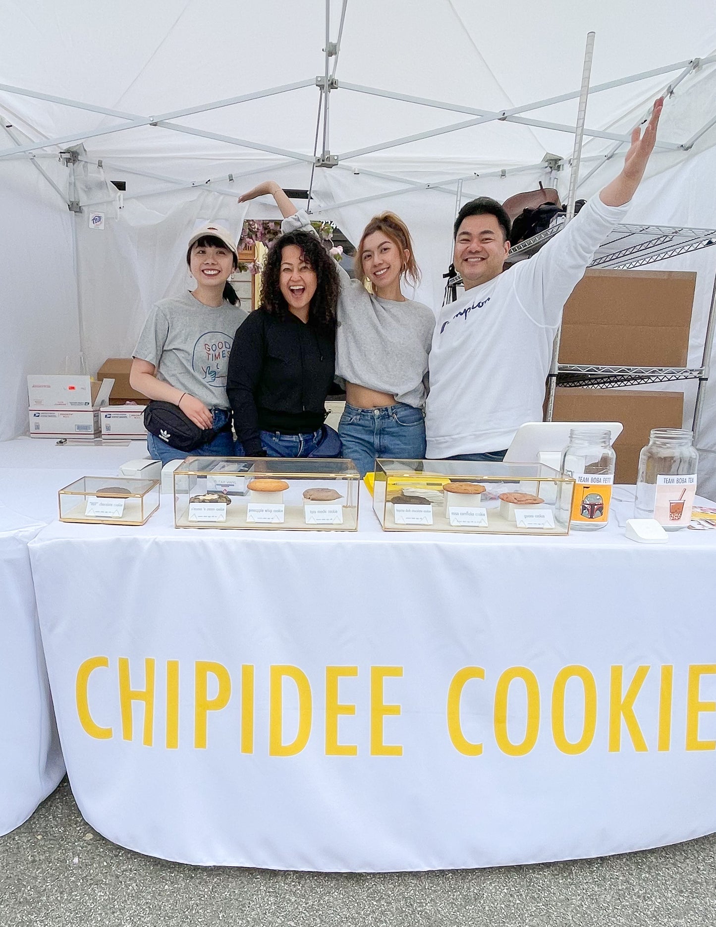 Chipidee Cookies' Asian American founder and employees at a pop-up booth, selling delectable cookies.